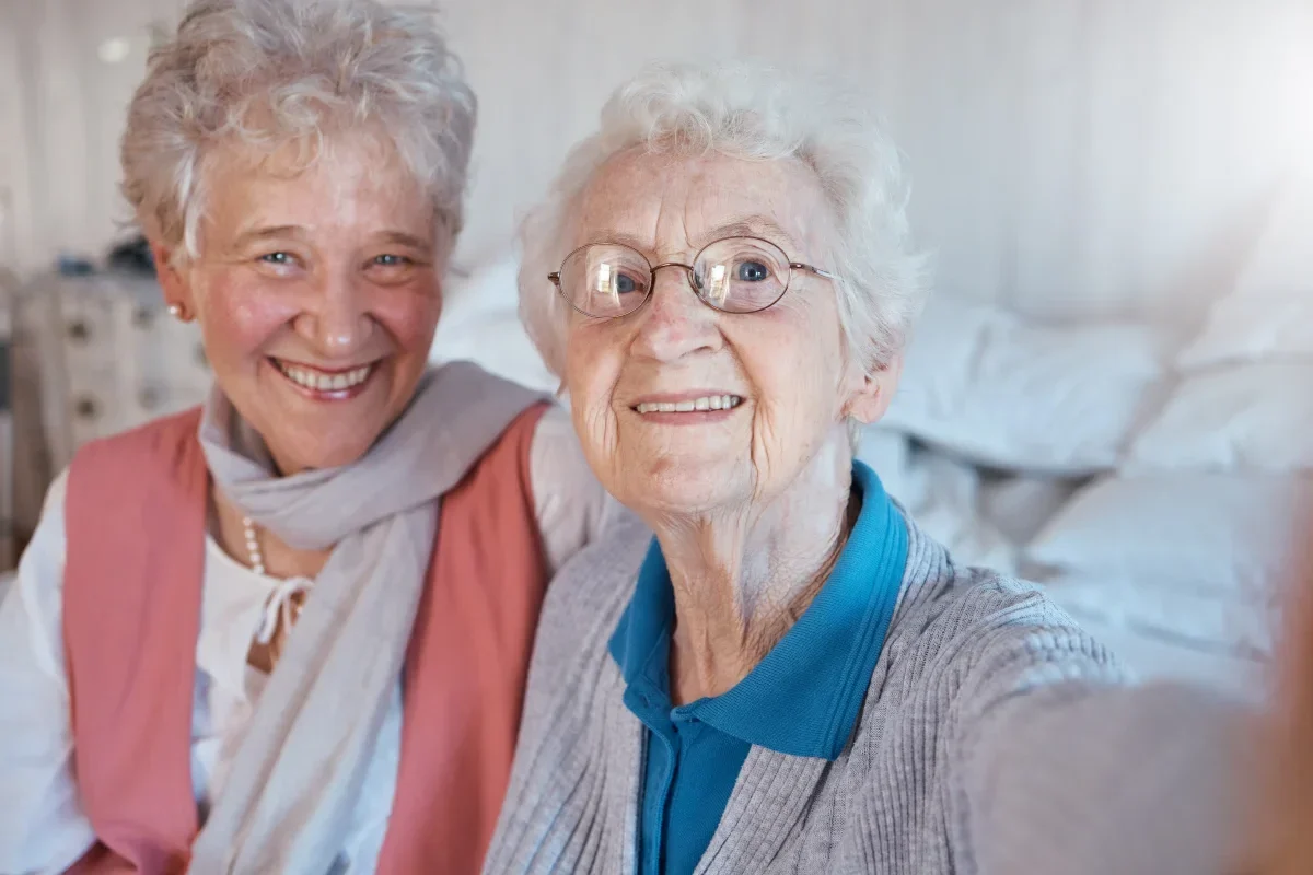 two senior women friends taking a selfie with a smile